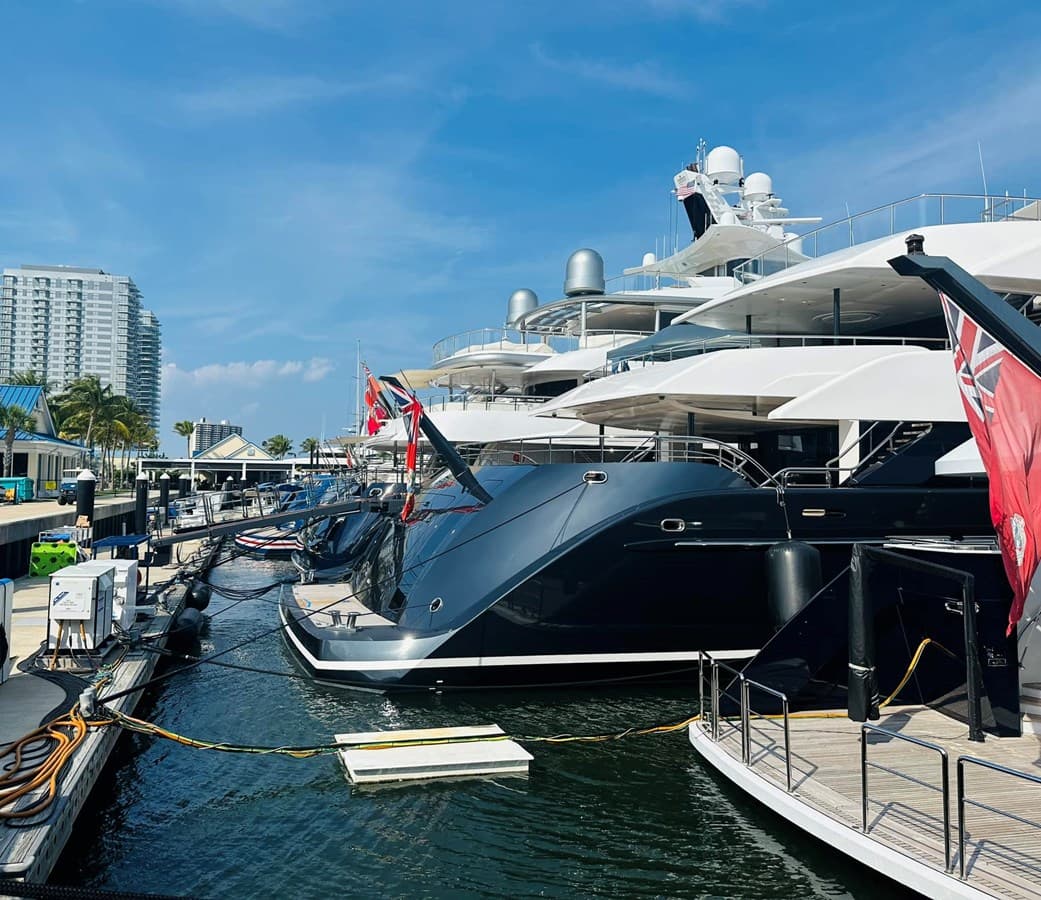 Superyachts berthed at a UIY-served marina under blue skies